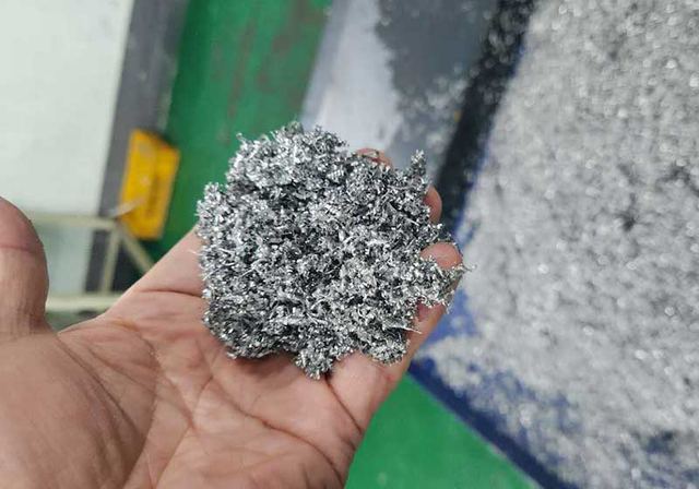 Hand holding loose aluminium machining chips